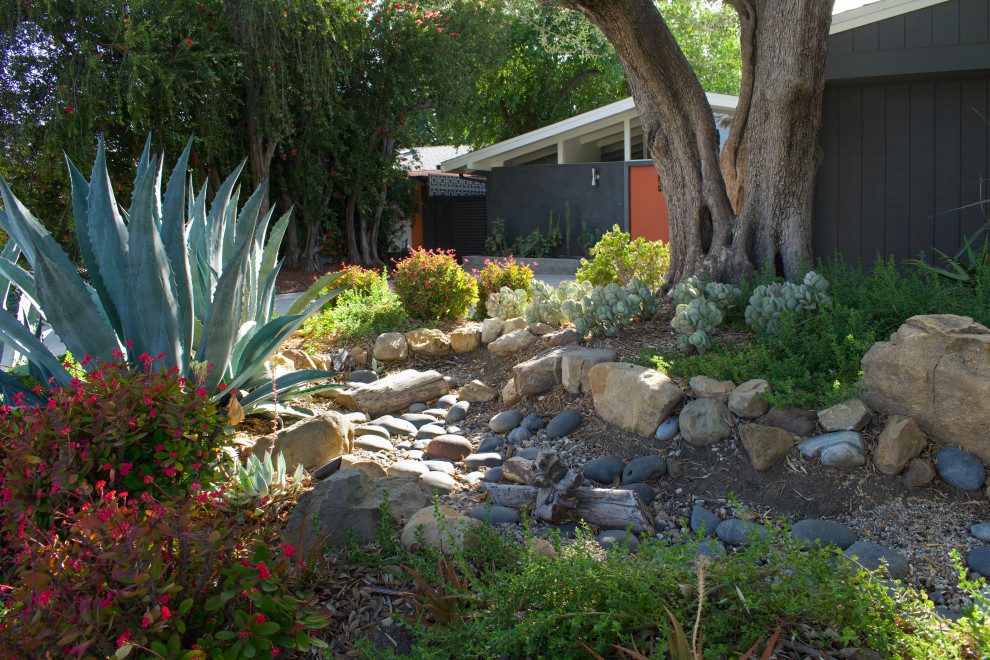Aménagement d'un jardin avant rétro de taille moyenne et l'hiver avec une exposition partiellement ombragée, des pavés en béton et une clôture en métal.