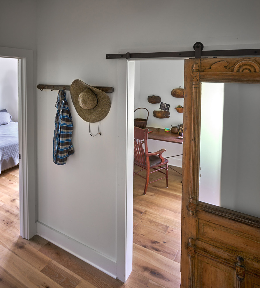 Design ideas for a small country hallway in Other with white walls and light hardwood floors.