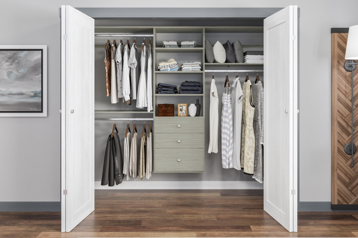 Example of a mid-sized transitional gender-neutral reach-in closet design in Grand Rapids with distressed cabinets and raised-panel cabinets