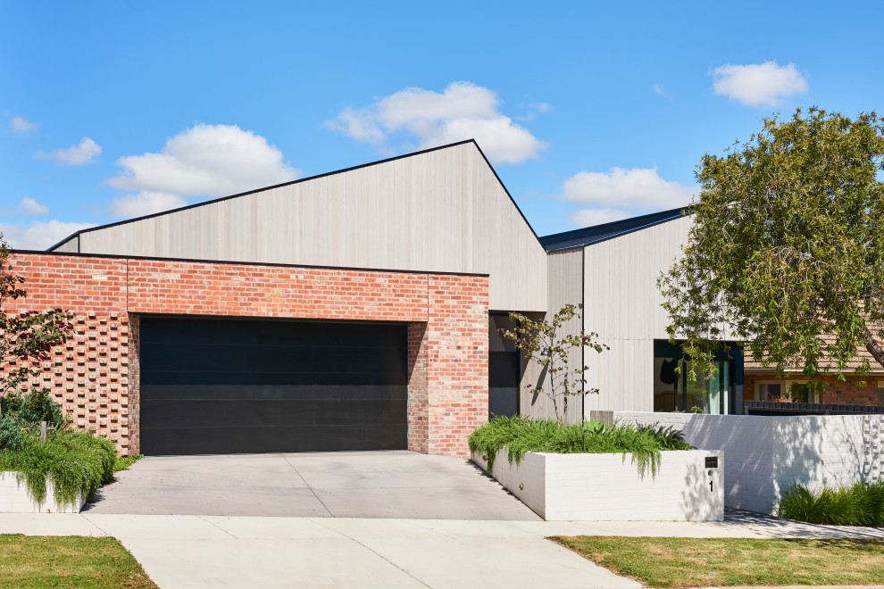 Design ideas for a mid-sized contemporary one-storey brick brown house exterior in Geelong with a metal roof and a gambrel roof.