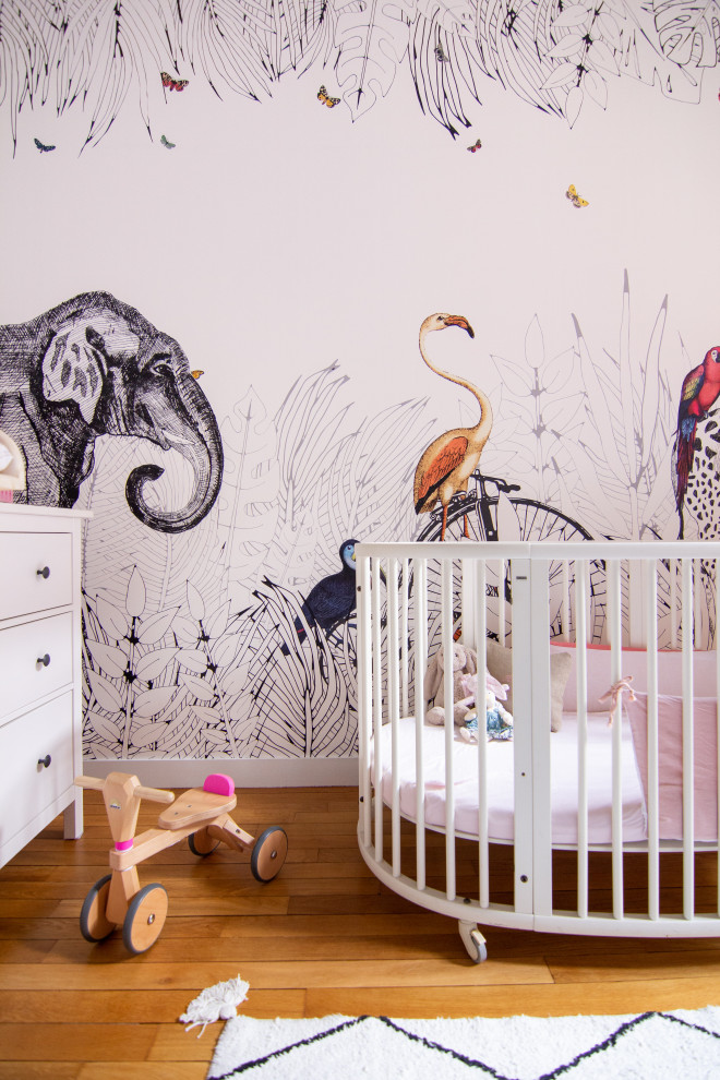 Inspiration for a mid-sized contemporary nursery for girls in Paris with beige walls and light hardwood floors.
