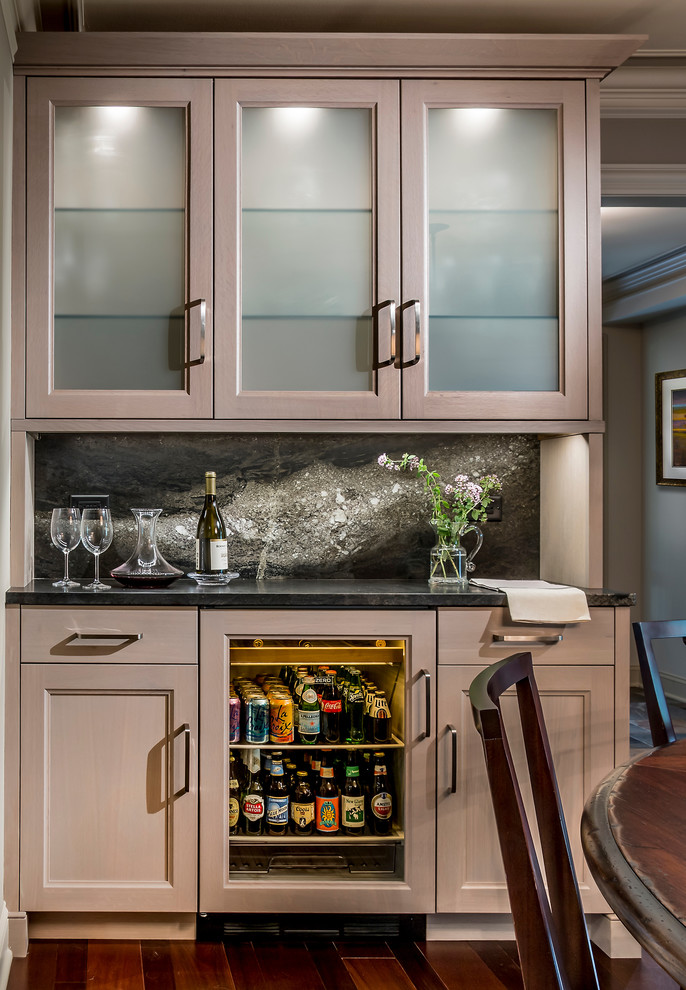 This is an example of a small transitional home bar in Chicago.