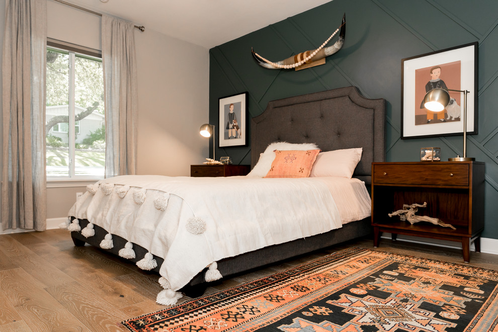 Eclectic guest bedroom in Austin with green walls, medium hardwood floors and beige floor.