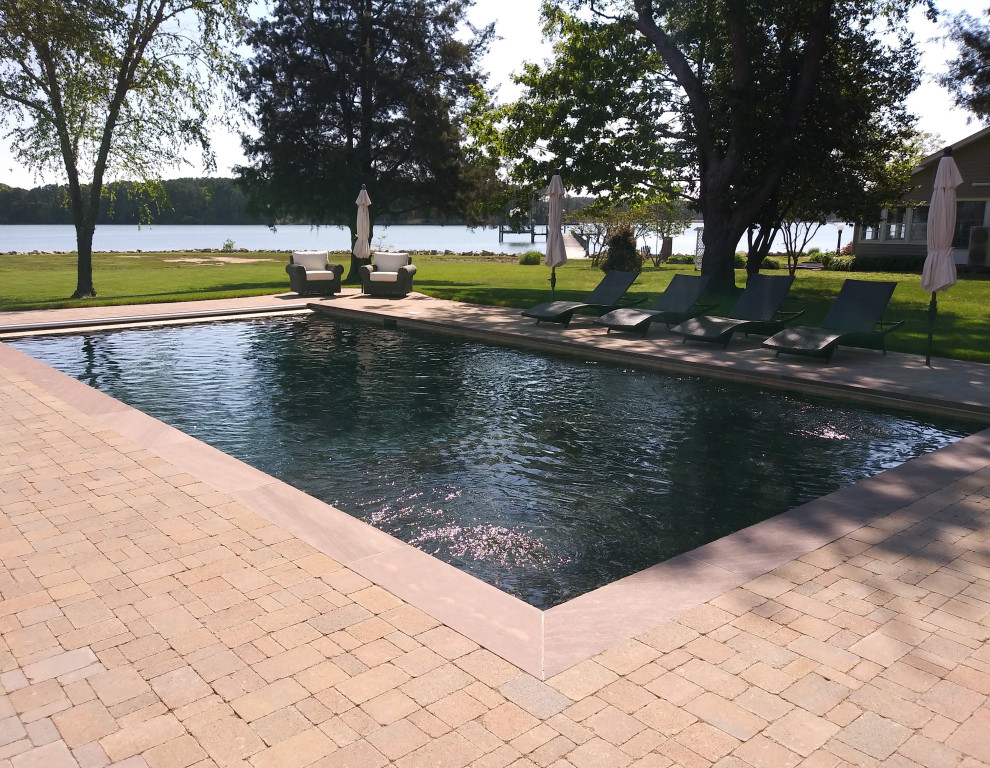 Imagen de piscina moderna de tamaño medio rectangular en patio lateral con adoquines de ladrillo