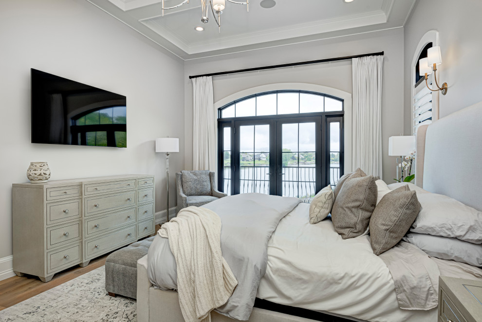 Diseño de dormitorio principal actual de tamaño medio con suelo de madera en tonos medios y paredes grises