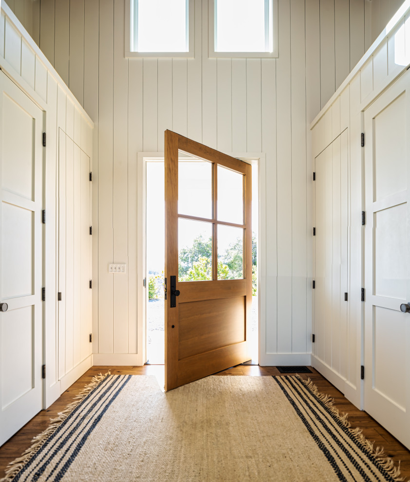 Geräumige Landhausstil Haustür mit weißer Wandfarbe, braunem Holzboden, Drehtür, hellbrauner Holzhaustür und braunem Boden in San Francisco