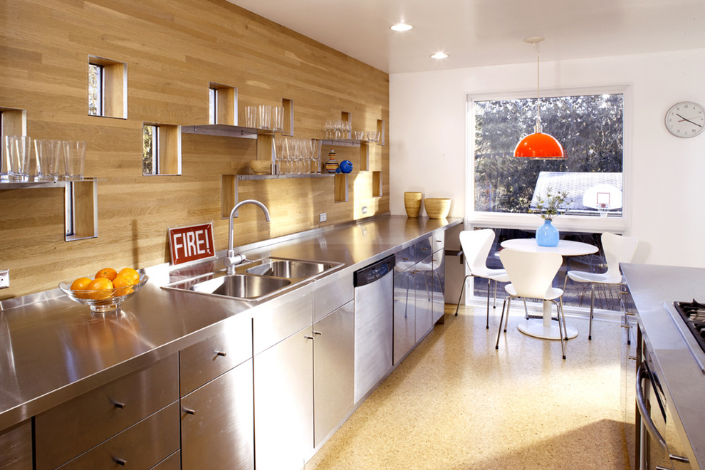 Photo of a mid-sized contemporary l-shaped eat-in kitchen in Minneapolis with a drop-in sink, stainless steel cabinets, stainless steel benchtops, flat-panel cabinets, cork floors and with island.