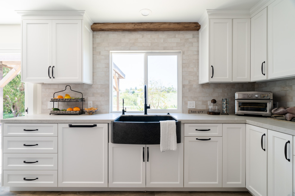 Exempel på ett stort maritimt vit vitt kök, med en rustik diskho, luckor med infälld panel, vita skåp, bänkskiva i kvartsit, vitt stänkskydd, stänkskydd i keramik, rostfria vitvaror, klinkergolv i porslin, en köksö och brunt golv