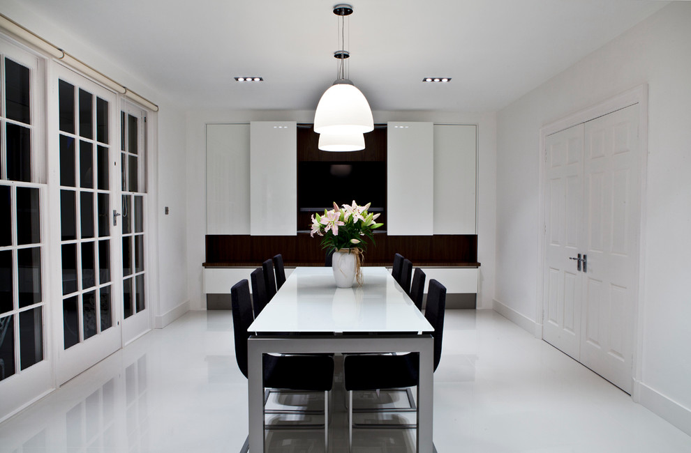 Contemporary separate dining room in London with white walls.