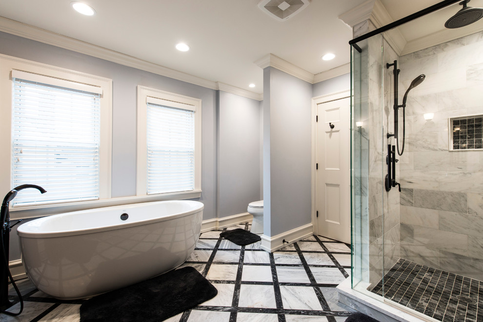 Design ideas for a large transitional master bathroom in Milwaukee with beaded inset cabinets, dark wood cabinets, a freestanding tub, a corner shower, black tile, white tile, marble, blue walls, marble floors, an undermount sink and marble benchtops.