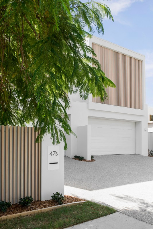 Inspiration for a mid-sized beach style two-storey white duplex exterior in Gold Coast - Tweed with a flat roof.