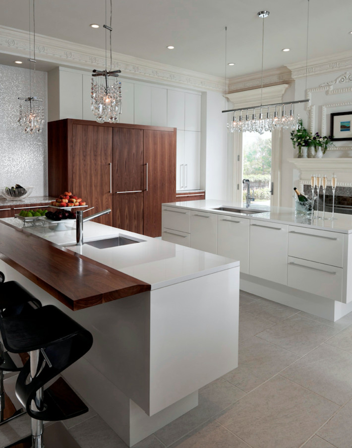 This is an example of a large contemporary galley separate kitchen in Miami with an undermount sink, flat-panel cabinets, medium wood cabinets, quartz benchtops, white splashback, stone slab splashback, panelled appliances, cement tiles, multiple islands and beige floor.