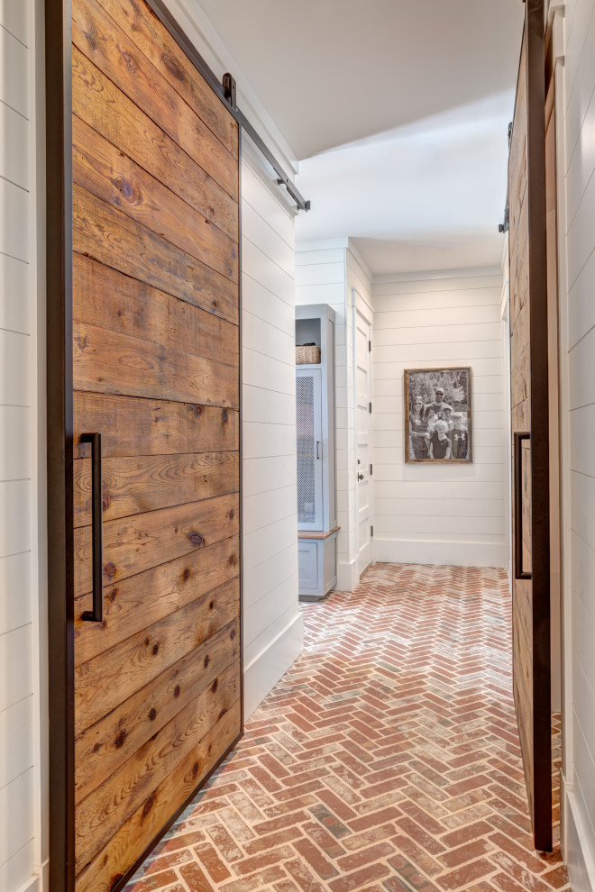 Photo of a country hallway in Charlotte with white walls, brick floors and red floor.
