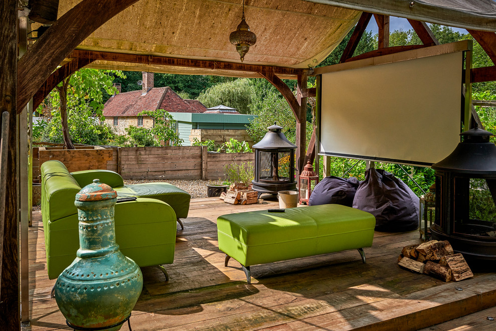 This is an example of an eclectic deck in Hampshire with a roof extension.