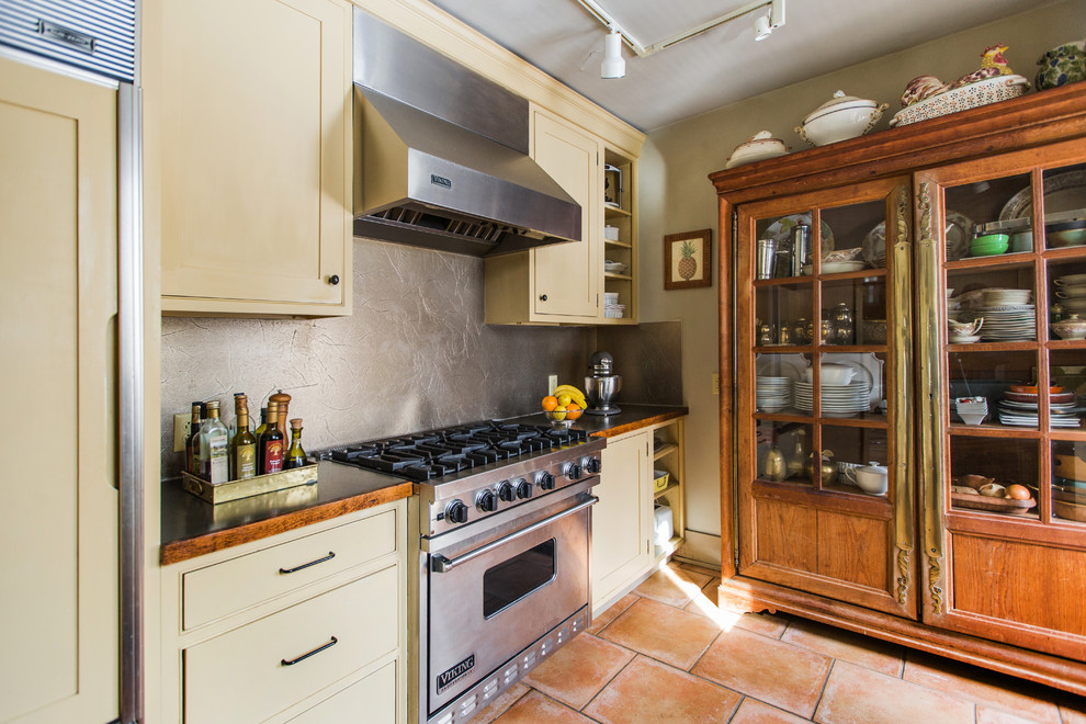 Inspiration for a mid-sized traditional galley separate kitchen in Philadelphia with an undermount sink, shaker cabinets, beige cabinets, copper benchtops, grey splashback, metal splashback, stainless steel appliances, terra-cotta floors, no island and red floor.