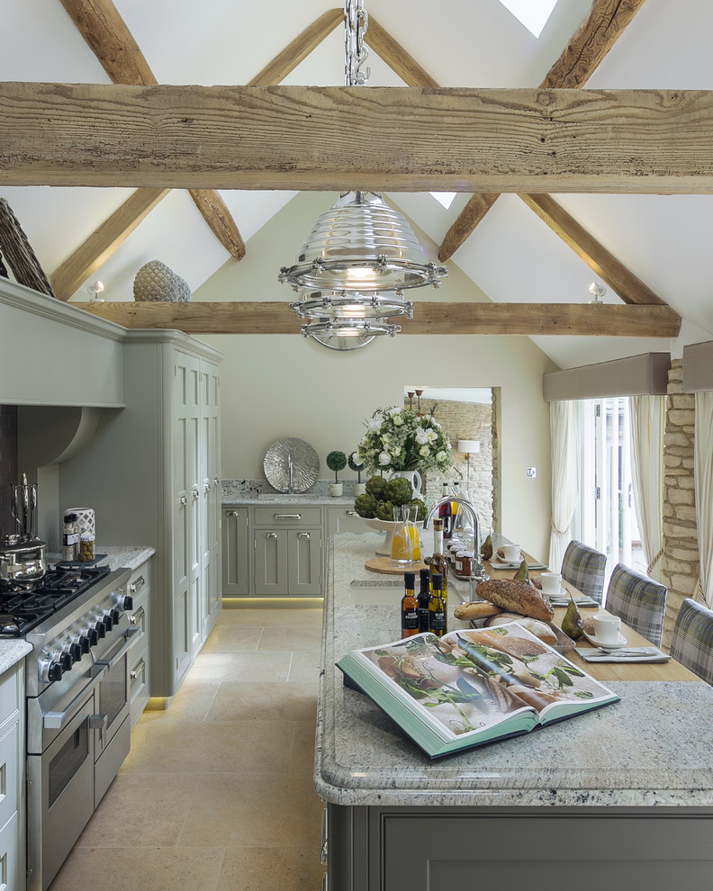 This is an example of a large country l-shaped separate kitchen in Gloucestershire with an undermount sink, shaker cabinets, green cabinets, granite benchtops, ceramic splashback, stainless steel appliances, limestone floors and with island.