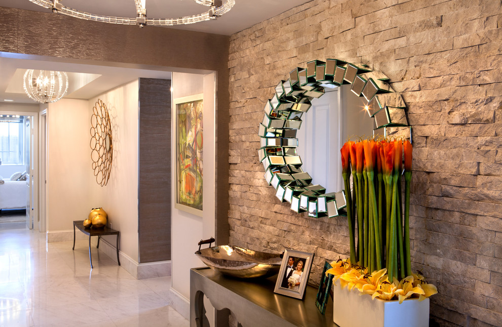 Photo of a mid-sized contemporary hallway in Miami with beige walls and marble floors.