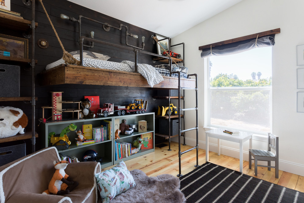 This is an example of a mid-sized country kids' bedroom for kids 4-10 years old and boys in Santa Barbara with white walls and light hardwood floors.