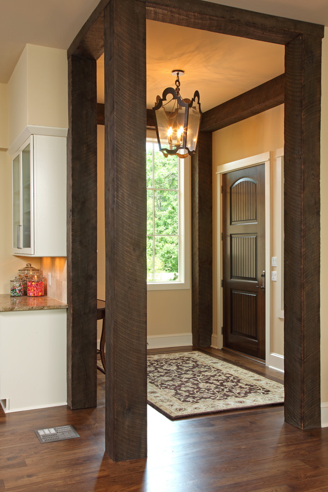 Foyer - rustic medium tone wood floor foyer idea in Minneapolis with beige walls and a dark wood front door