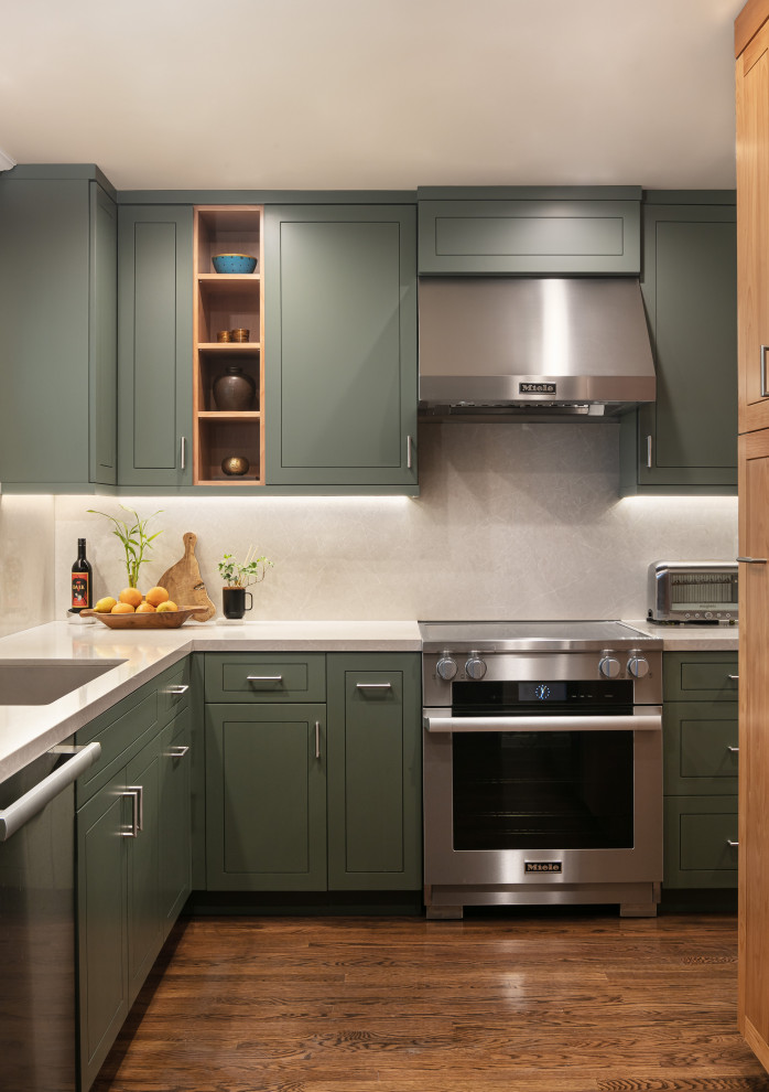 Eklektisk inredning av ett litet vit vitt kök, med en undermonterad diskho, luckor med upphöjd panel, gröna skåp, bänkskiva i kvarts, vitt stänkskydd, rostfria vitvaror och mörkt trägolv