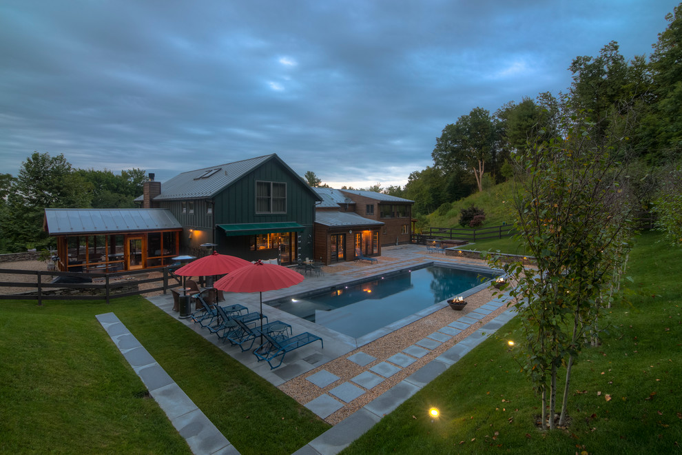 Example of a mid-sized mountain style backyard stone and rectangular lap pool design in New York