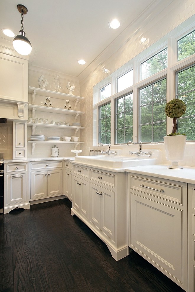 Traditional eat-in kitchen in Chicago with a drop-in sink, white cabinets, marble benchtops, white splashback, subway tile splashback and beaded inset cabinets.
