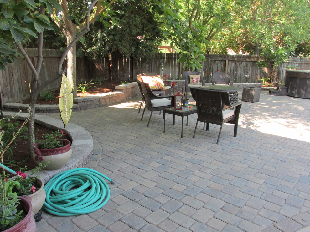Photo of a mid-sized country backyard patio in Other with concrete pavers.