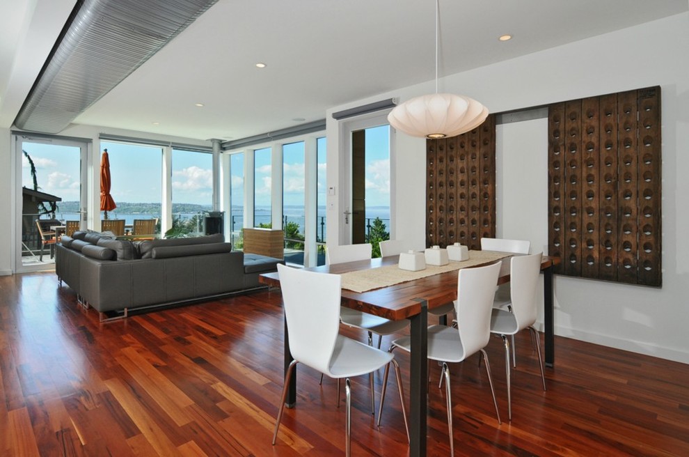 Modern dining room in Seattle with white walls and dark hardwood floors.