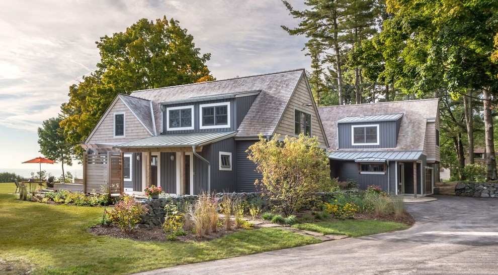 Mid-sized beach style two-storey grey exterior in Milwaukee with a gable roof, mixed siding and a shingle roof.