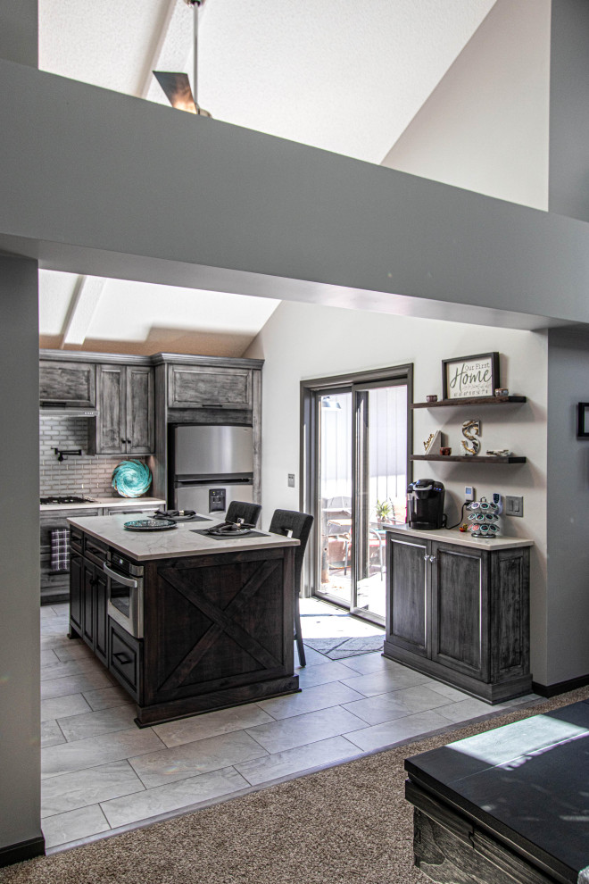 Mid-sized transitional l-shaped eat-in kitchen in Cleveland with an undermount sink, flat-panel cabinets, grey cabinets, grey splashback, glass tile splashback, stainless steel appliances, ceramic floors, with island, grey floor and white benchtop.