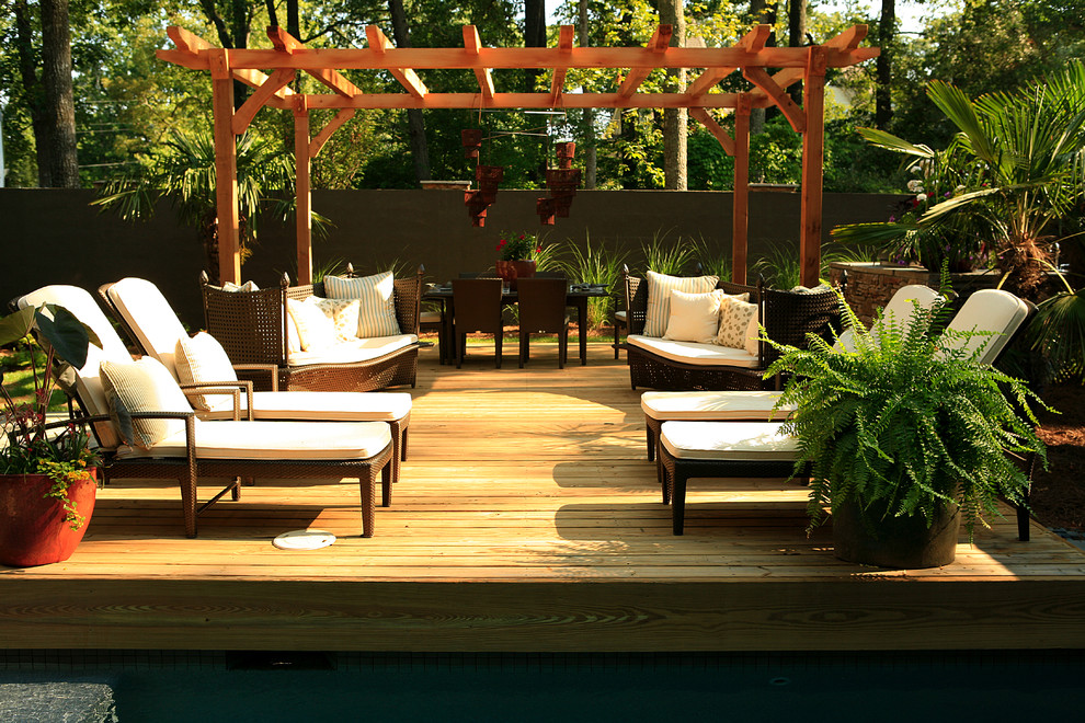 Photo of a tropical deck in Atlanta with a pergola.