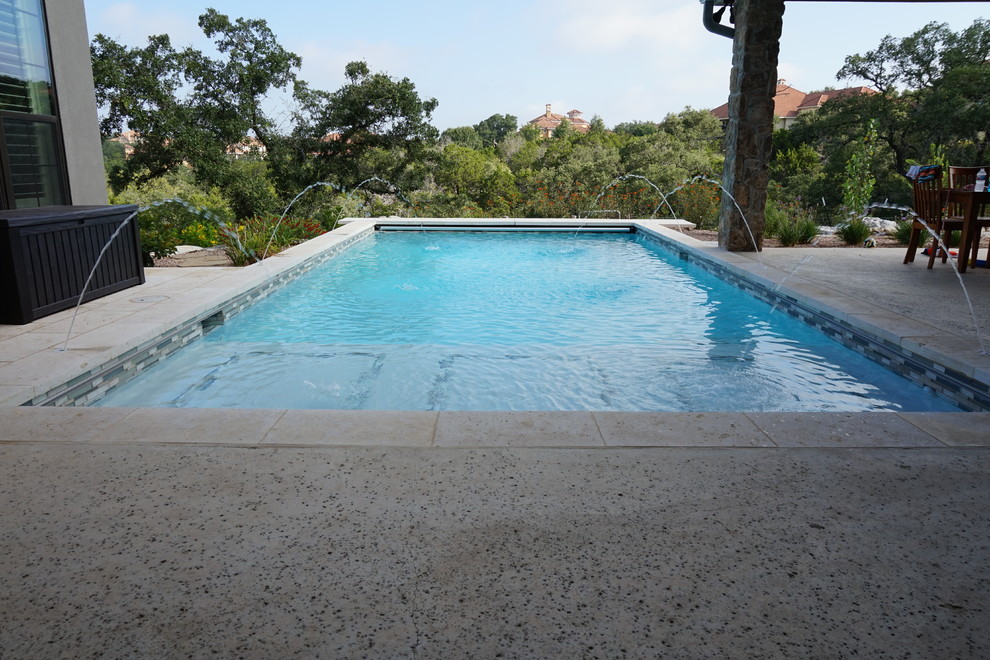 Design ideas for a large arts and crafts backyard rectangular lap pool in Austin with a water feature and gravel.