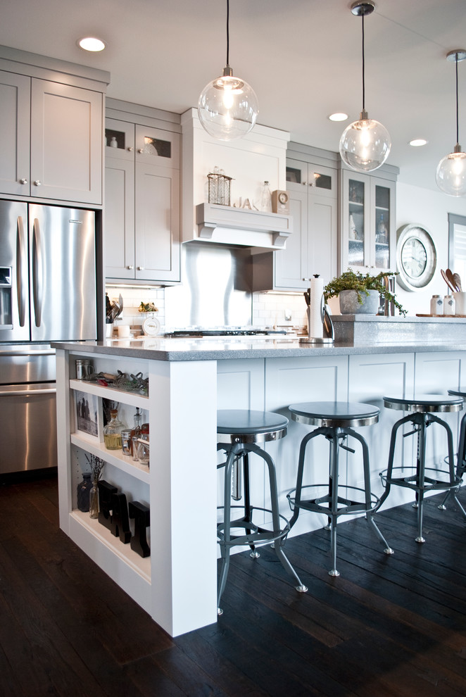 Inspiration for a large transitional l-shaped open concept kitchen remodel with an undermount sink, flat-panel cabinets, gray cabinets, quartzite countertops, white backsplash, subway tile backsplash, stainless steel appliances and an island