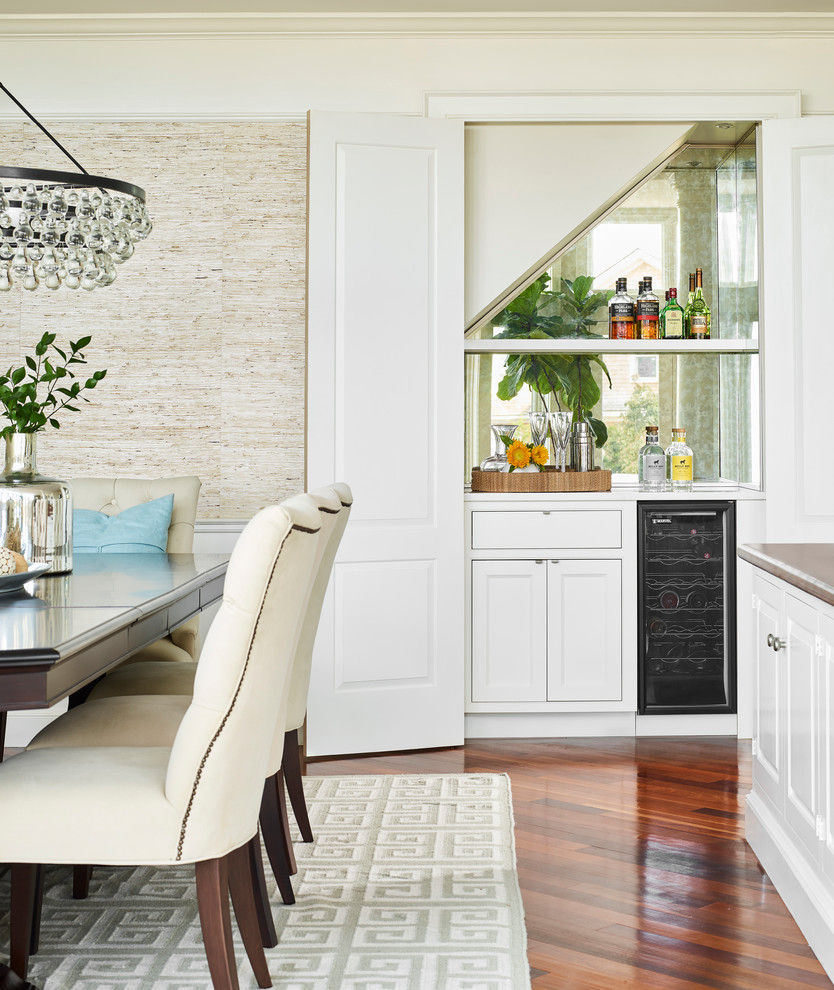 Inspiration for a beach style single-wall home bar in Boston with white cabinets, no sink, shaker cabinets, mirror splashback, medium hardwood floors and white benchtop.