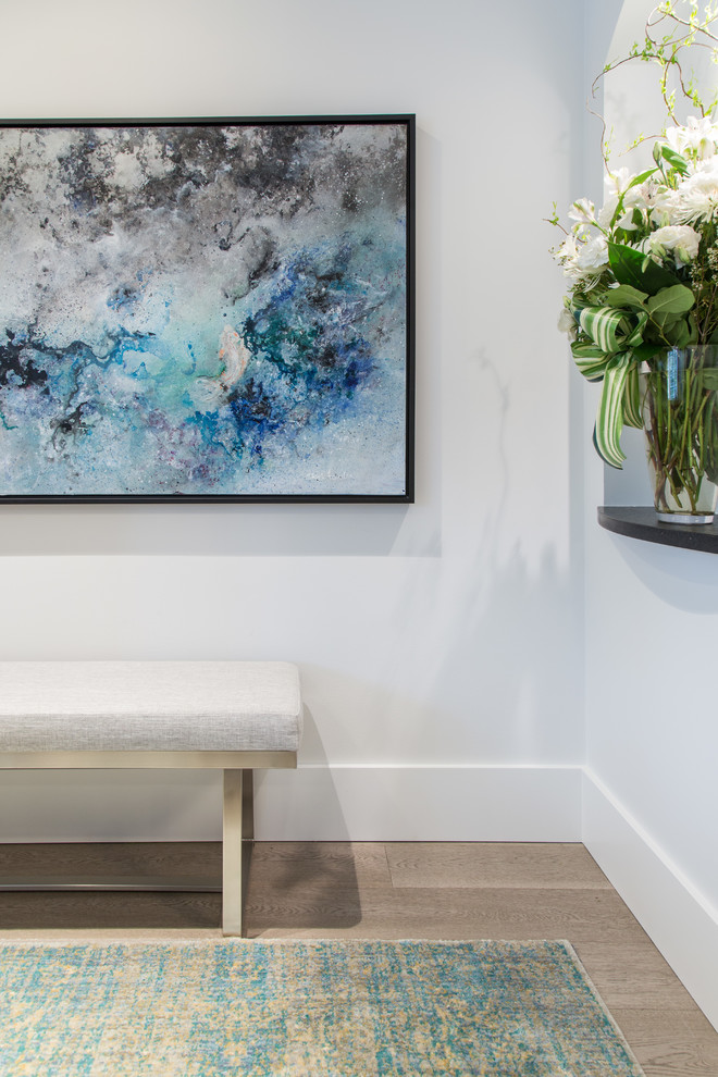Foyer - small transitional medium tone wood floor and beige floor foyer idea in Vancouver with gray walls and a gray front door