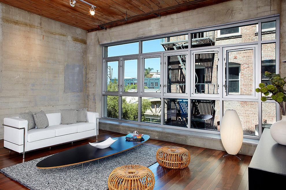 Photo of an industrial open concept living room in Los Angeles with dark hardwood floors and no fireplace.