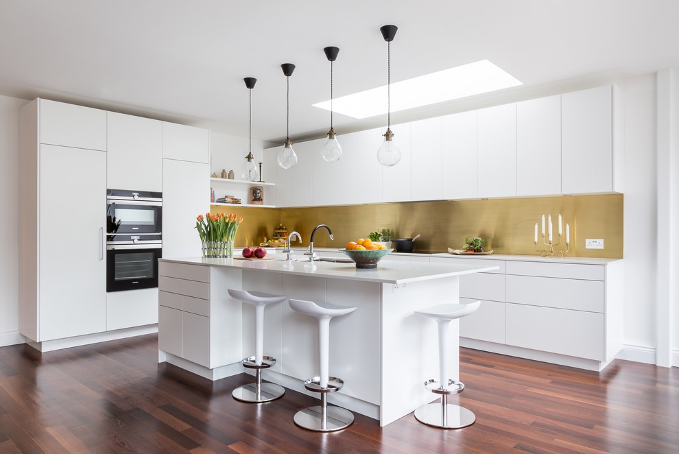Photo of a large contemporary l-shaped eat-in kitchen in London with flat-panel cabinets, white cabinets, metallic splashback, dark hardwood floors, with island, brown floor and a double-bowl sink.