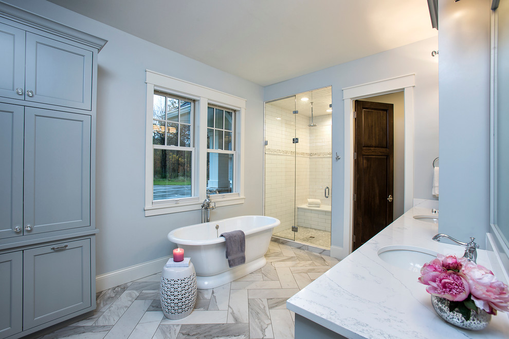 This is an example of a large transitional master bathroom in Minneapolis with recessed-panel cabinets, grey cabinets, a freestanding tub, an alcove shower, white tile, subway tile, grey walls, an undermount sink and engineered quartz benchtops.
