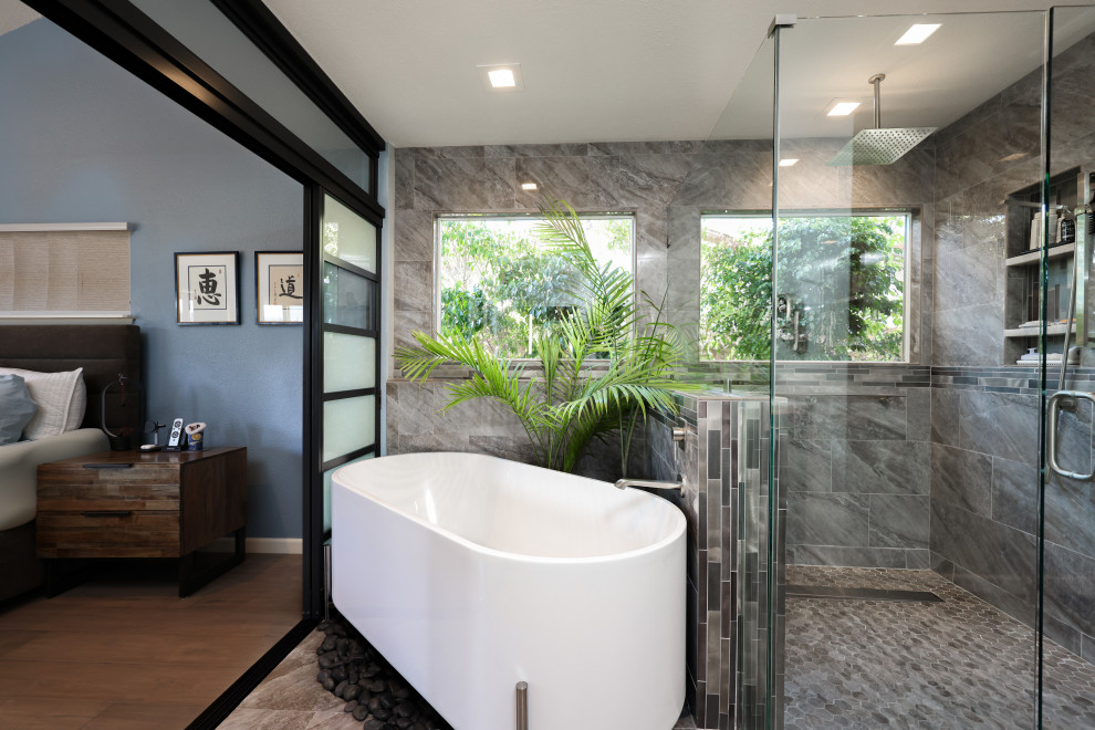 This is an example of a large midcentury master bathroom in San Diego with flat-panel cabinets, dark wood cabinets, a freestanding tub, an open shower, a one-piece toilet, gray tile, porcelain tile, grey walls, porcelain floors, an undermount sink, onyx benchtops, multi-coloured floor, a hinged shower door, multi-coloured benchtops, a laundry, a double vanity and a built-in vanity.