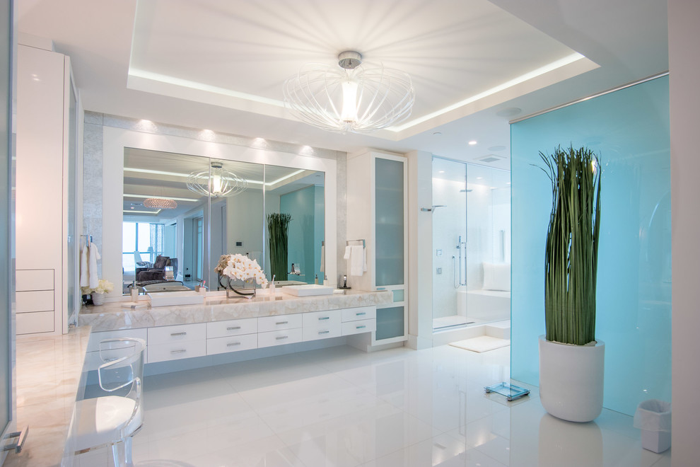 This is an example of a contemporary bathroom in Miami with flat-panel cabinets, white cabinets, an alcove shower, white tile and a vessel sink.