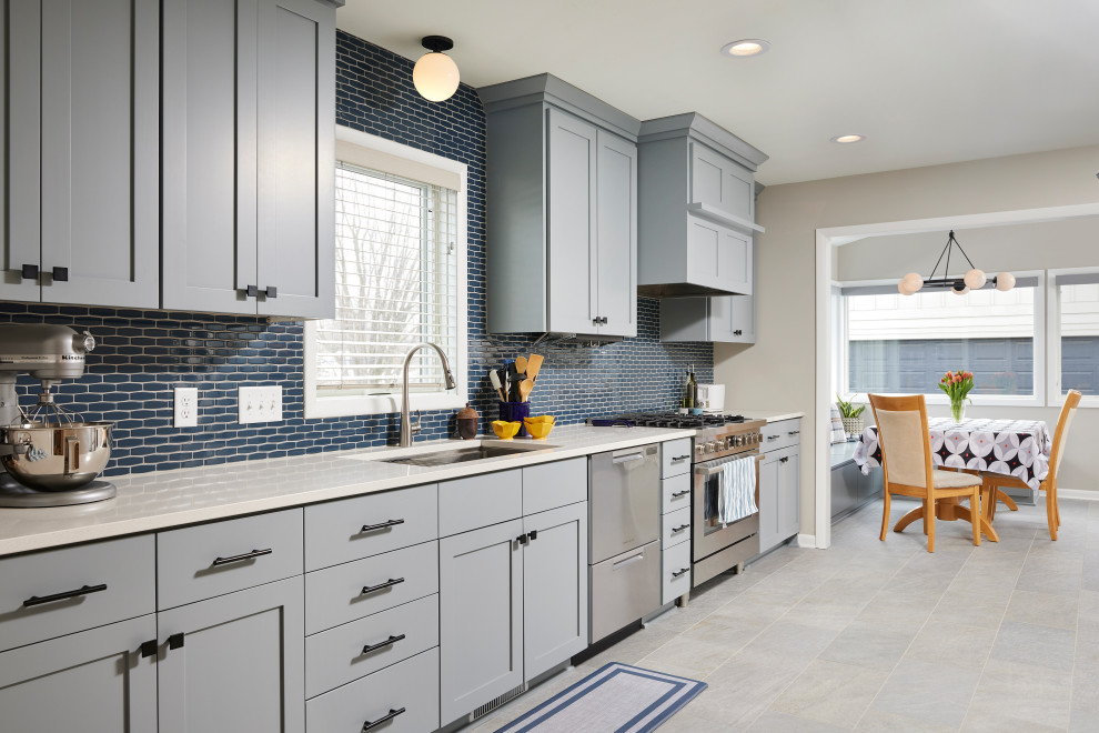 Mid-sized contemporary eat-in kitchen in Minneapolis with an undermount sink, shaker cabinets, grey cabinets, quartz benchtops, blue splashback, ceramic splashback, stainless steel appliances, porcelain floors, no island, grey floor and white benchtop.
