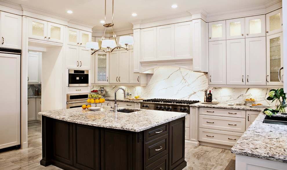 Example of a mid-sized transitional u-shaped porcelain tile eat-in kitchen design in Toronto with shaker cabinets, white cabinets, granite countertops, white backsplash, stone slab backsplash, paneled appliances, an island and a drop-in sink