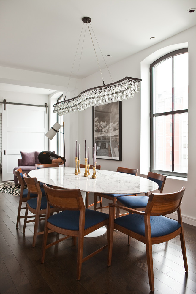 This is an example of a contemporary dining room in New York with white walls and dark hardwood floors.
