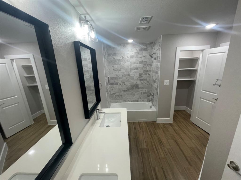Design ideas for a mid-sized modern kids bathroom in Houston with furniture-like cabinets, white cabinets, an open shower, a one-piece toilet, black tile, porcelain tile, white walls, wood-look tile, an undermount sink, marble benchtops, grey floor, an open shower, white benchtops, a niche, a single vanity, a built-in vanity and planked wall panelling.