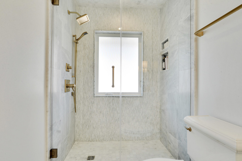 This is an example of a mid-sized transitional 3/4 bathroom in New Orleans with raised-panel cabinets, white cabinets, an alcove shower, a two-piece toilet, gray tile, white tile, marble, white walls, marble floors and an undermount sink.