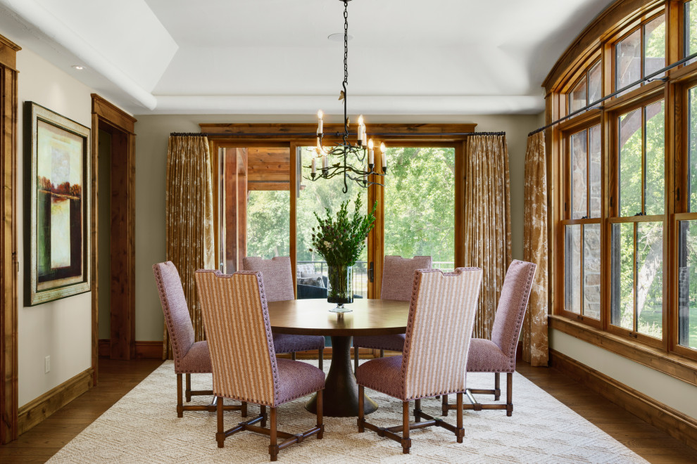 Idée de décoration pour une salle à manger ouverte sur la cuisine chalet de taille moyenne avec un mur beige, un sol en bois brun, un sol marron et poutres apparentes.