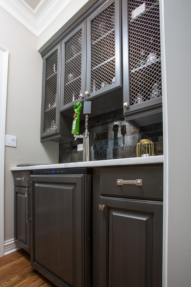 Inspiration for a large transitional u-shaped medium tone wood floor eat-in kitchen remodel in Chicago with white cabinets, white backsplash, stainless steel appliances and an island