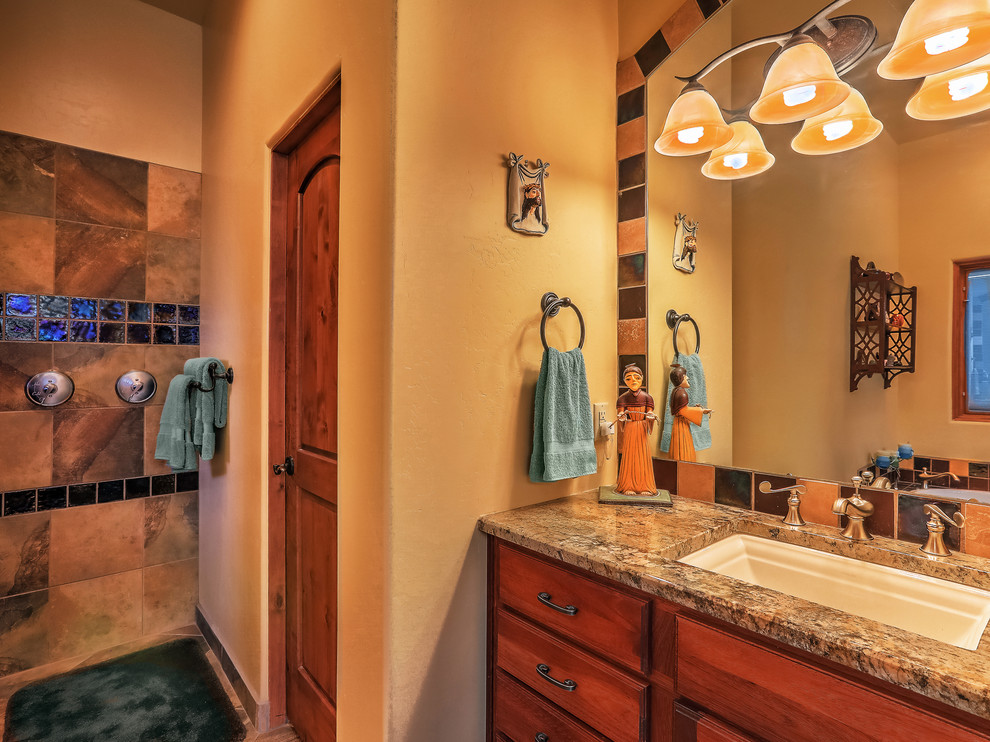 Mid-sized master bathroom in Albuquerque with flat-panel cabinets, medium wood cabinets, a corner tub, an open shower, multi-coloured tile, ceramic tile, yellow walls, slate floors, an undermount sink, granite benchtops, multi-coloured floor, an open shower and brown benchtops.