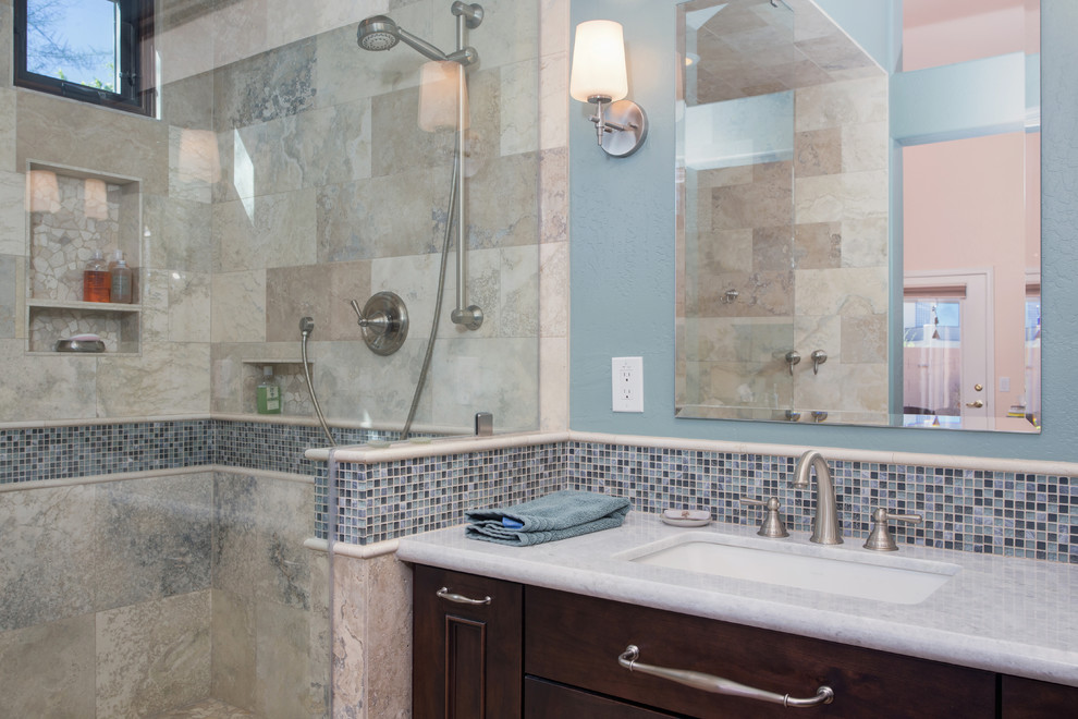 Large transitional master gray tile and stone tile ceramic tile walk-in shower photo in Phoenix with an undermount sink, raised-panel cabinets, dark wood cabinets, granite countertops and blue walls