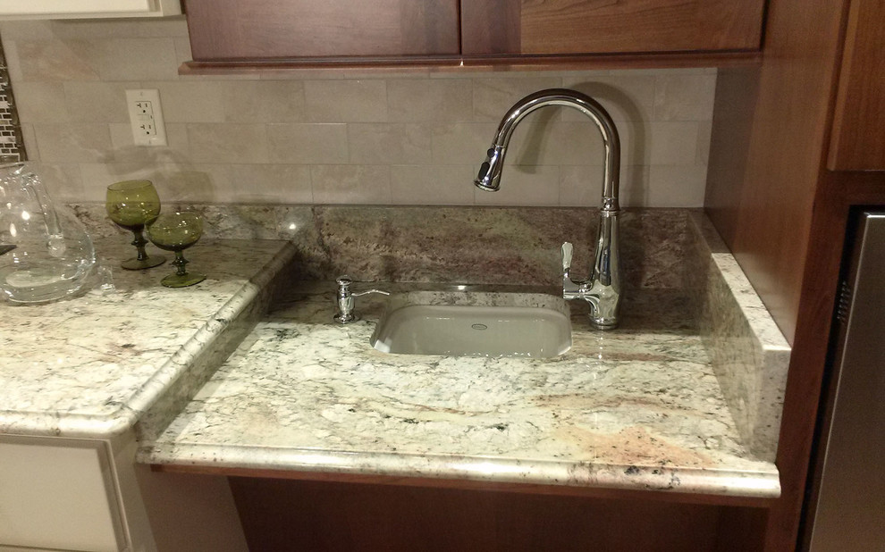 Large transitional l-shaped medium tone wood floor open concept kitchen photo with an undermount sink, shaker cabinets, medium tone wood cabinets, granite countertops, beige backsplash, ceramic backsplash, white appliances and an island